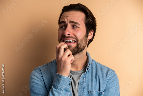 Portrait of frighten man with beard looking confused afraid shy, indicating something scary