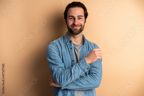 Image of a pleased caucasian guy posing isolated over orange wall background