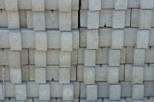gray stone texture of a row of concrete slabs in the wall in the street