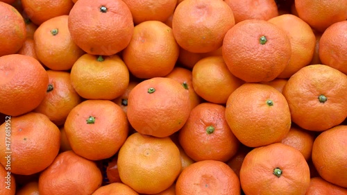 Fresh mandarins on fruit market, close up. Boxes full of ripe mandarin oranges for sale in supermarket. Fresh fruit display in shop. Juicy mandarin orange at the greengrocer's stall.  photo