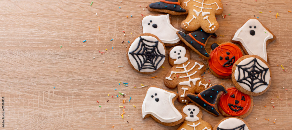 Various Halloween gingerbread cookies - Jack O'Lanterns, ghosts, bat and black hat on wood background. Halloween concept. Top view.