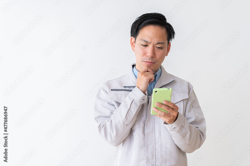 ビジネスマン 作業服 スマホ 考える ビジネスマン 作業服 スマホ 考える