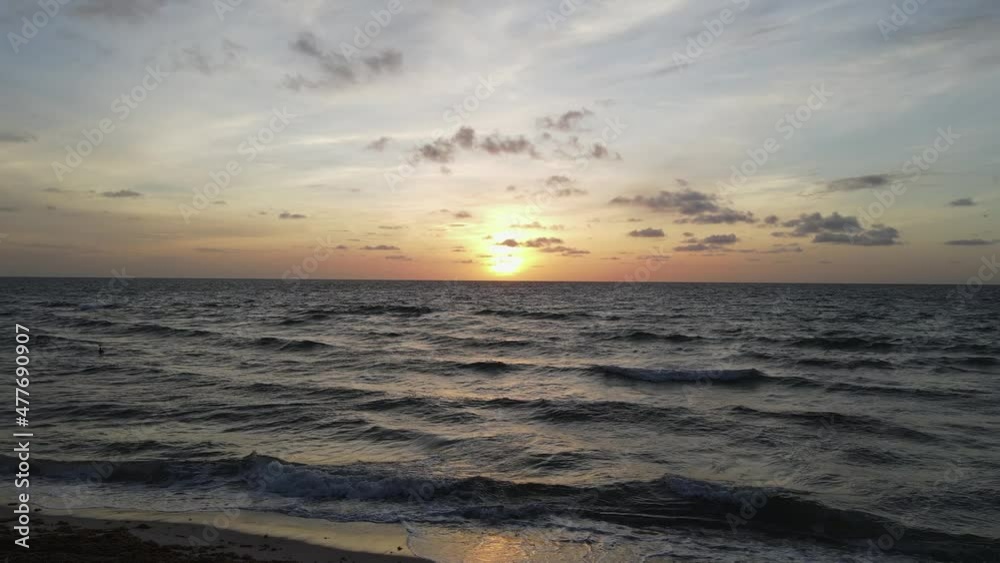 Dark golden ocean sunrise with sand beach and dramatic red sky horizon Dark golden ocean sunrise with sand beach and dramatic red sky horizon