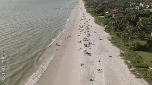 People enjoy white sandy ocean beach on sunny warm Florida gulf coast photo