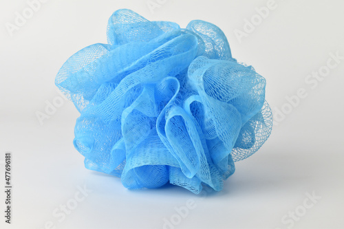 Exfoliating device in the shower Made from blue plastic fibers. on a white background