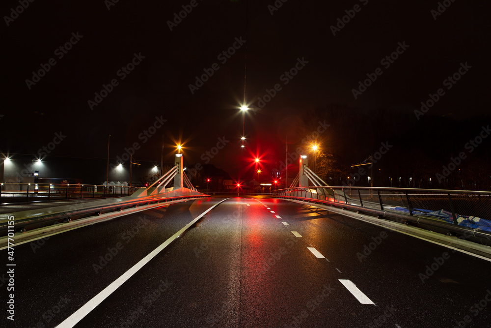 Bridge with busy street and traffic lights at night