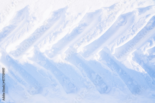 Traces of tractor wheels in the snow. The imprint of the tread of municipal services equipment during snow clearing. Top view