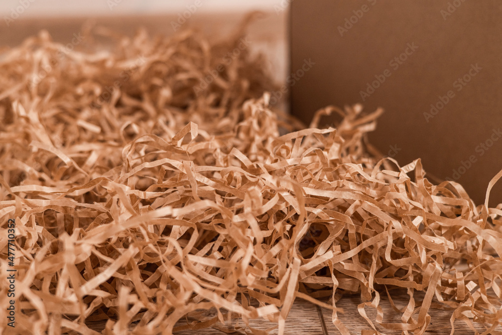 Moving day, box with paper material.Eco material for packaging goods, things, fragile items. Decorative wood shavings
