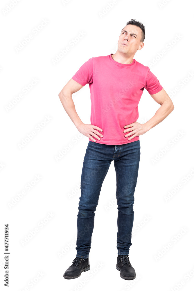 Thoughtful man standing with hands on waist and looking away