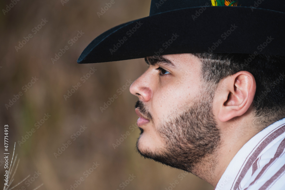 JOVEN MEXICANO CANTANDO CON SU GUITARRA USA SOMBRERO Y TIENE BARBA JOVEN MEXICANO CANTANDO CON SU GUITARRA USA SOMBRERO Y TIENE BARBA