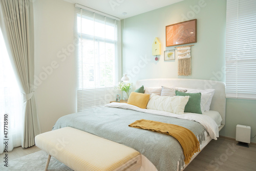 Stylish bedroom with modern green and yellow pillow and furniture. Interior design