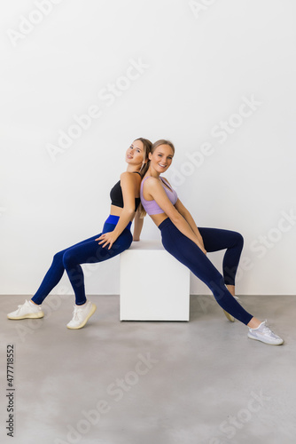 Two fit women exercising isolated on white background