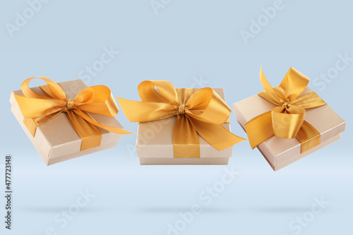 Beautifully wrapped gift boxes flying on light blue background