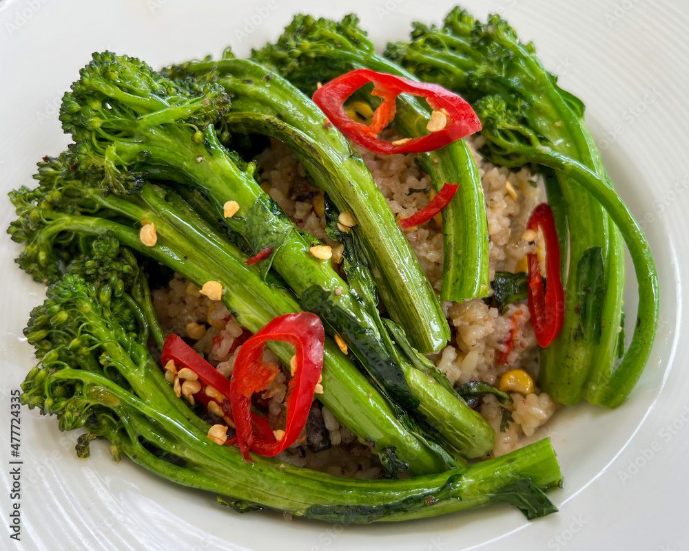 A plate of cooked green broccoli with sea salt, shot from above A plate of cooked green broccoli with sea salt, shot from above