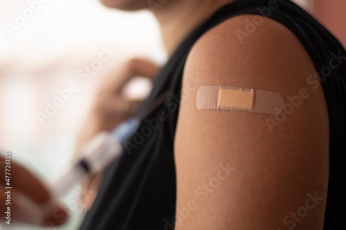 Covid-19 vaccination done. Vaccine concept. Smiling caucasian woman, closeup of arm. Coronavirus pandemic period