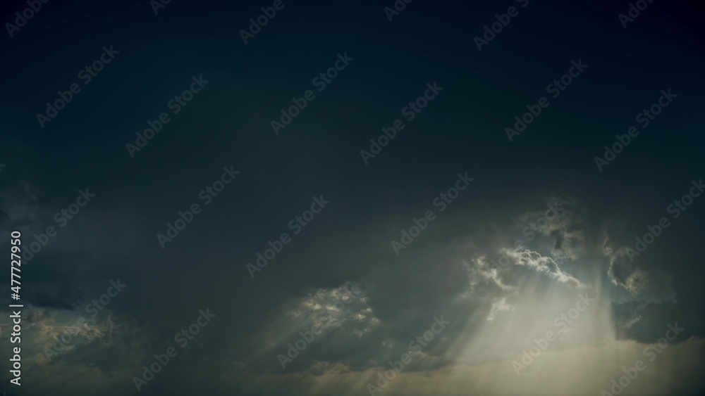 4K Sun Rays Shining Through Dark Storm Cloudy Rainy Sky With Fluffy Rain Clouds. Sky Natural Background. Weather Forecast Concept