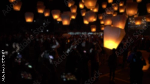 Defocused shot of many asian fire lanterns launching during buddhist festival in chinese new year in Taipei. Rice paper hot air balloons floating in traditional flying sky lantern celebration photo