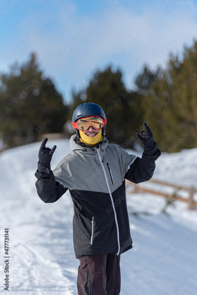Young man snowboarding on the slopes of a ski resort.