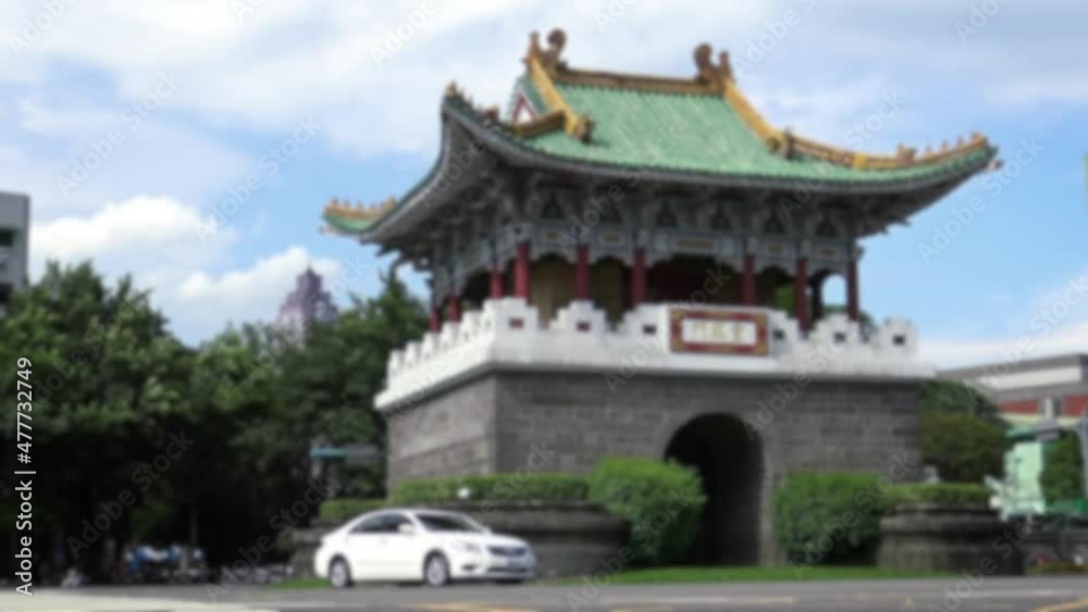 Blurred defocused view of Taipei Auxiliary South Gate in Taiwan. Traffic Cars, Motorbikes and Different Vehicles Driving On The Road near the Gate in the city. Blue sky in summer sun day. Blurred defocused view of Taipei Auxiliary South Gate in Taiwan. Traffic Cars, Motorbikes and Different Vehicles Driving On The Road near the Gate in the city. Blue sky in summer sun day.