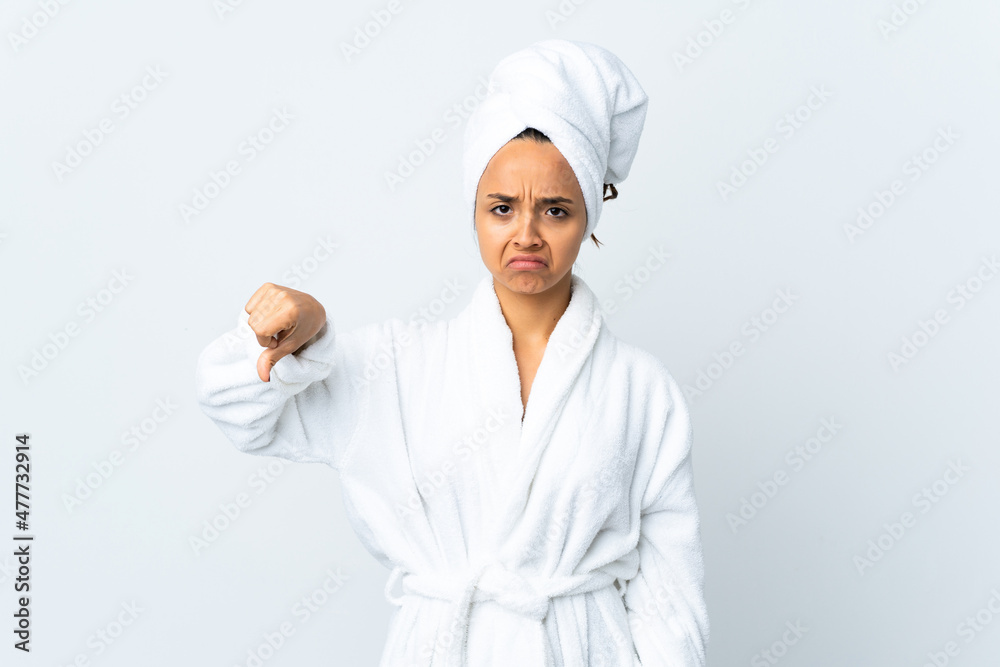 Young woman in bathrobe over isolated white background showing thumb down with negative expression Young woman in bathrobe over isolated white background showing thumb down with negative expression