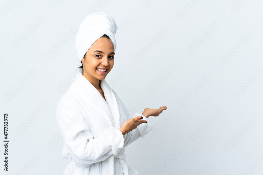 Young woman in bathrobe over isolated white background extending hands to the side for inviting to come Young woman in bathrobe over isolated white background extending hands to the side for inviting to come