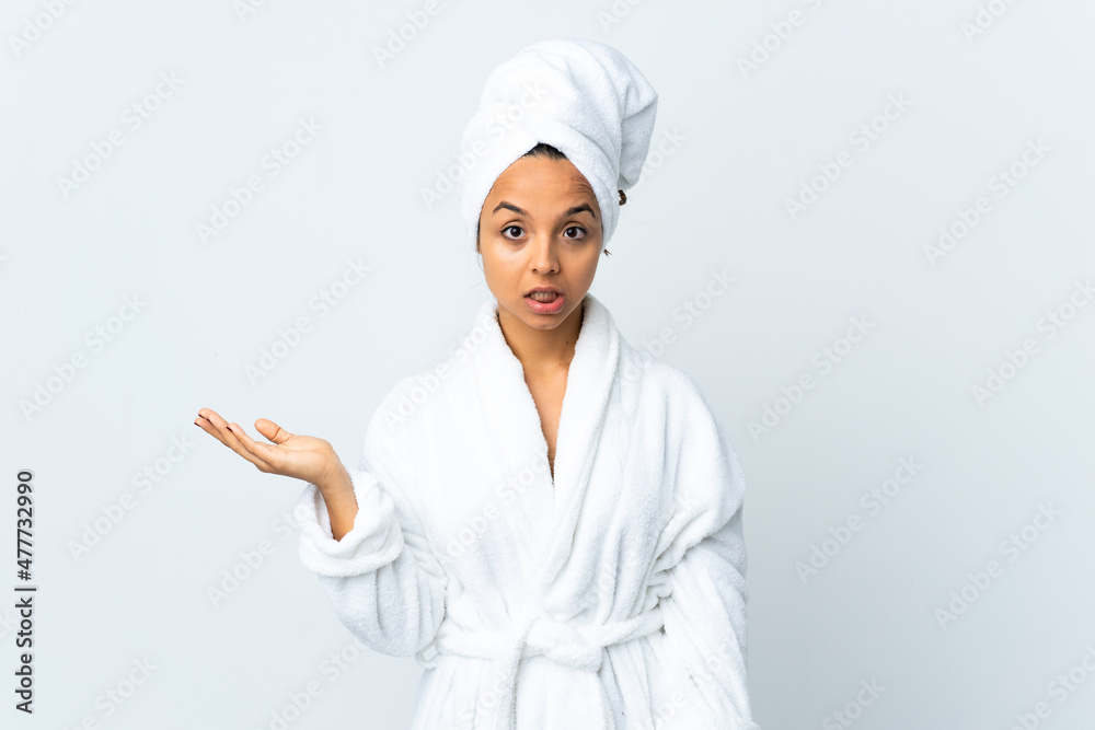 Young woman in bathrobe over isolated white background making doubts gesture Young woman in bathrobe over isolated white background making doubts gesture