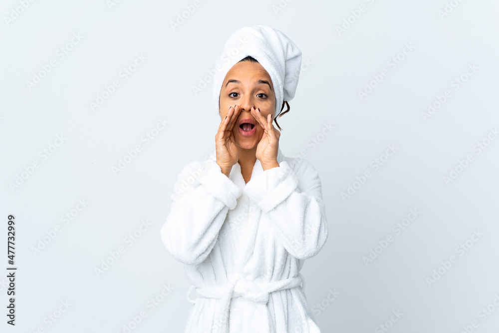 Young woman in bathrobe over isolated white background shouting and announcing something Young woman in bathrobe over isolated white background shouting and announcing something