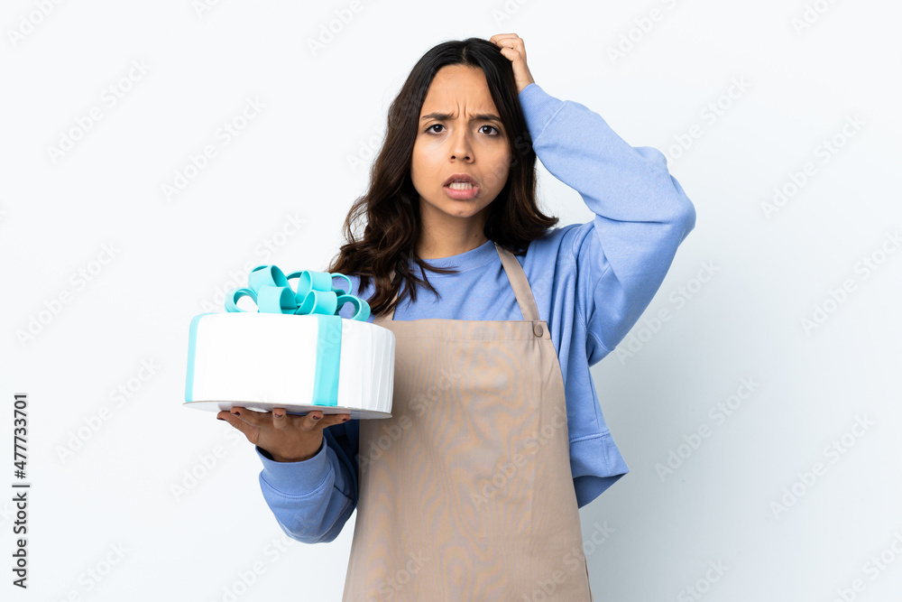 Pastry chef holding a big cake over isolated white background with an expression of frustration and not understanding Pastry chef holding a big cake over isolated white background with an expression of frustration and not understanding