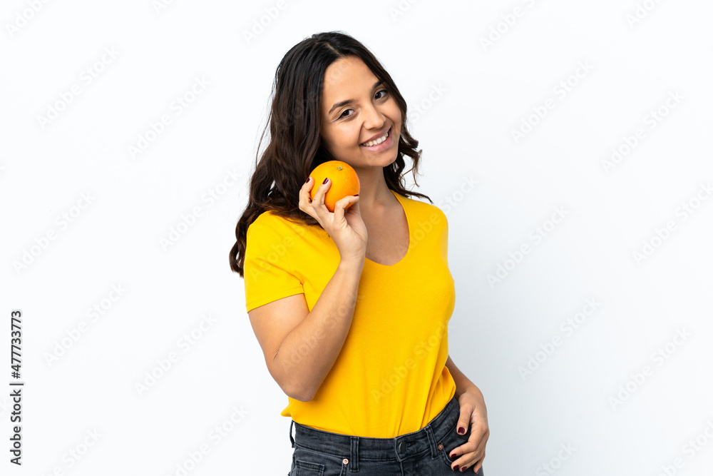 Young woman over isolated white background holding an orange Young woman over isolated white background holding an orange