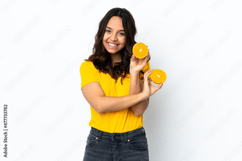 Young woman over isolated white background holding an orange Young woman over isolated white background holding an orange