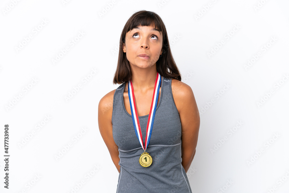 Young mixed race woman with medals isolated on white background and looking up Young mixed race woman with medals isolated on white background and looking up