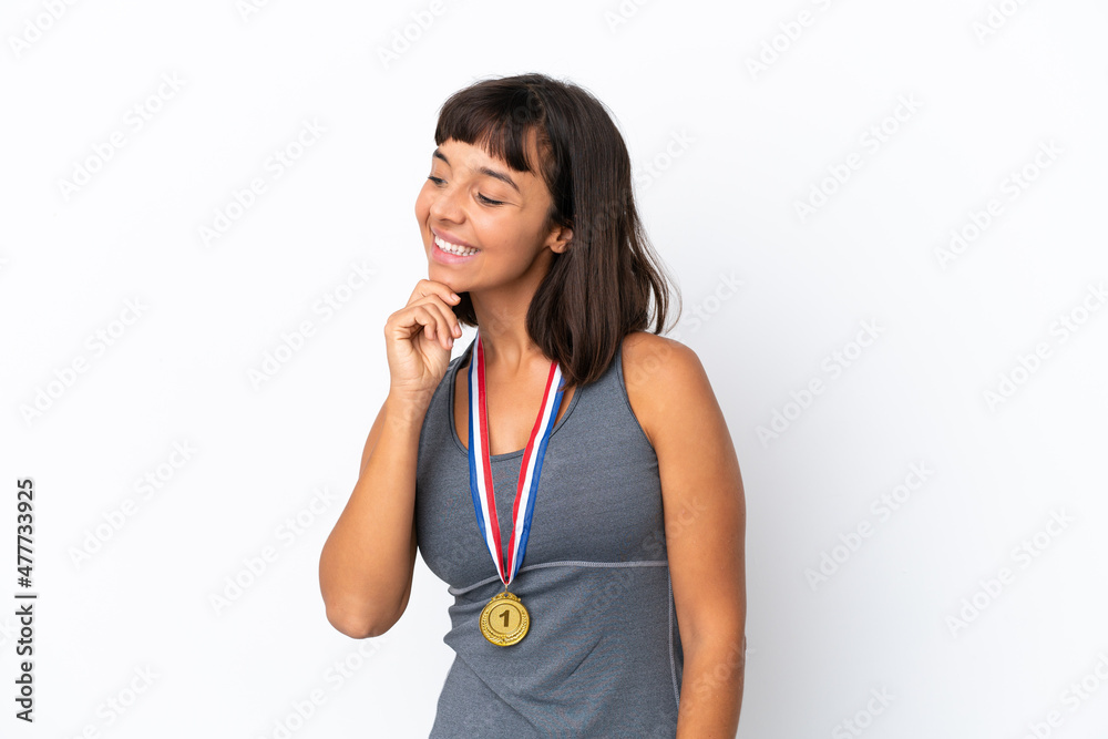 Young mixed race woman with medals isolated on white background looking to the side Young mixed race woman with medals isolated on white background looking to the side