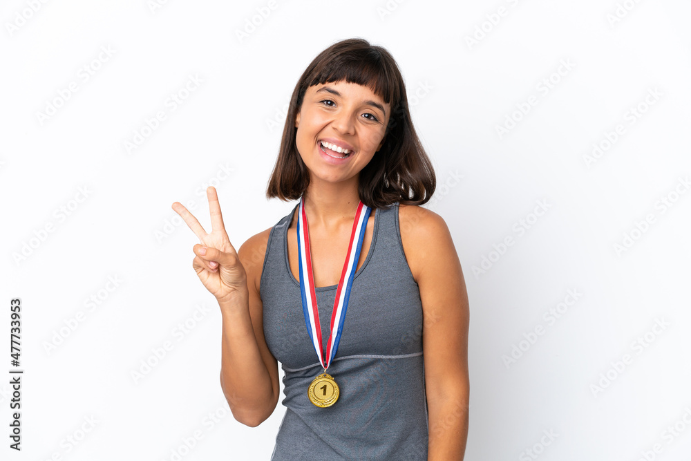 Young mixed race woman with medals isolated on white background smiling and showing victory sign Young mixed race woman with medals isolated on white background smiling and showing victory sign