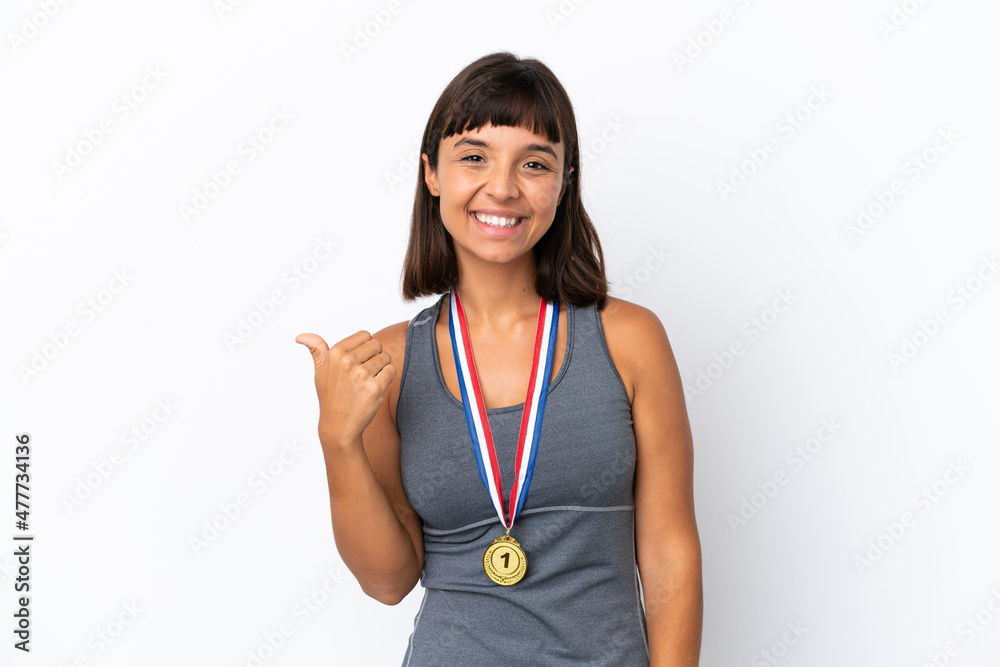 Young mixed race woman with medals isolated on white background pointing to the side to present a product Young mixed race woman with medals isolated on white background pointing to the side to present a product