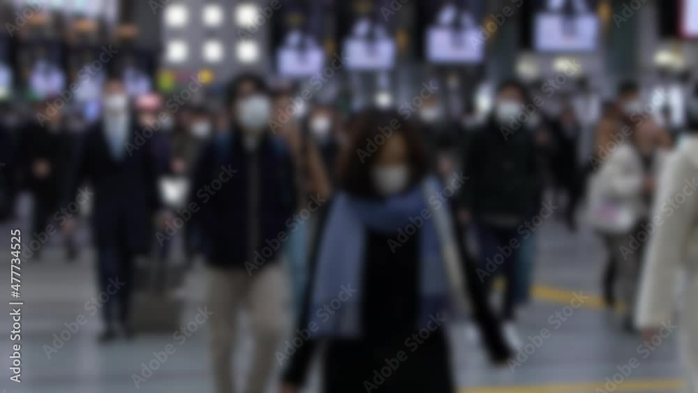 Defocused and slowmotion shot of large crowd business people inside metro station wearing surgical mask. Omicron variant coronavirus pneumonia. Blurred background in the scene Defocused and slowmotion shot of large crowd business people inside metro station wearing surgical mask. Omicron variant coronavirus pneumonia. Blurred background in the scene