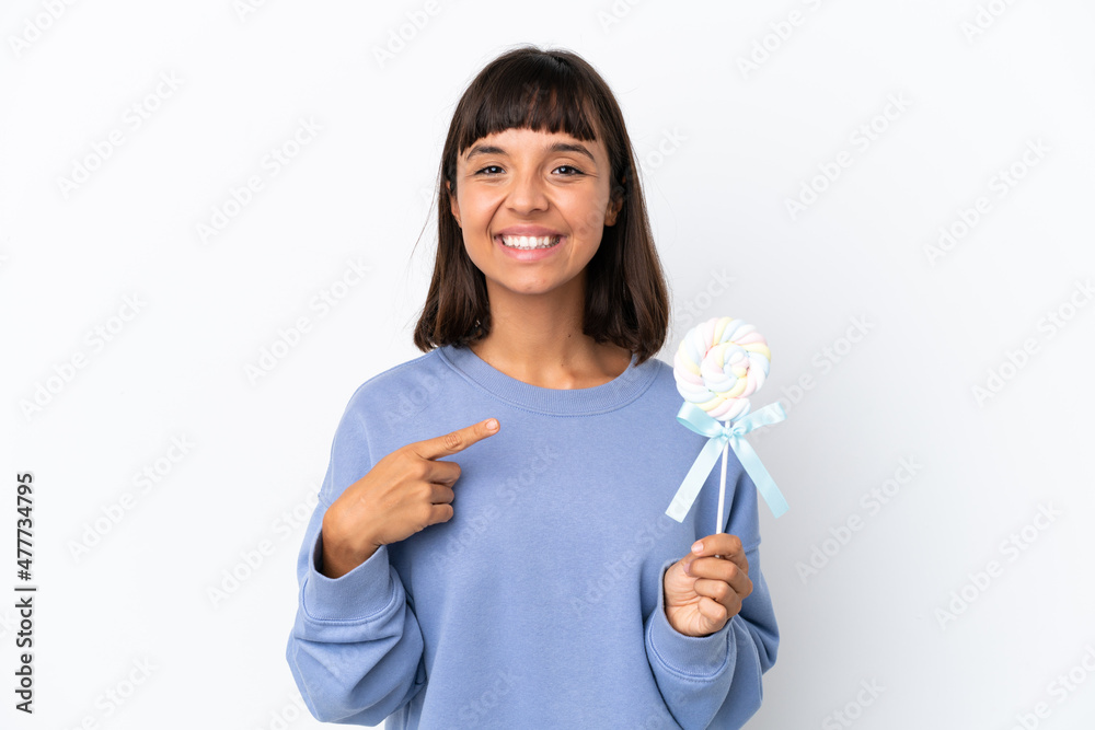 Young mixed race woman holding a lollipop isolated on white background pointing to the side to present a product Young mixed race woman holding a lollipop isolated on white background pointing to the side to present a product
