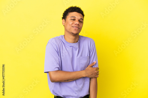 Young African American man isolated on yellow background laughing