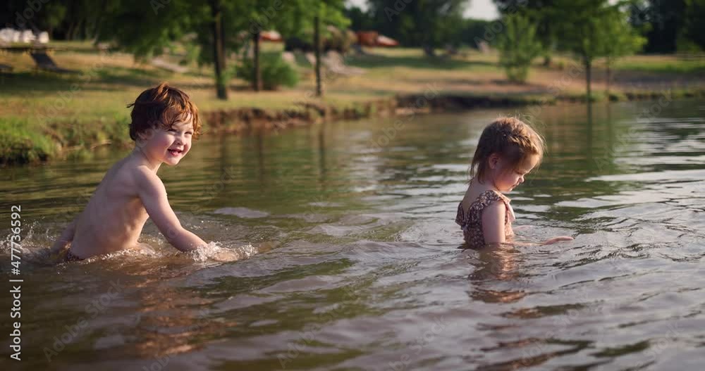 happy kids swimming in the lake at summer evening happy kids swimming in the lake at summer evening