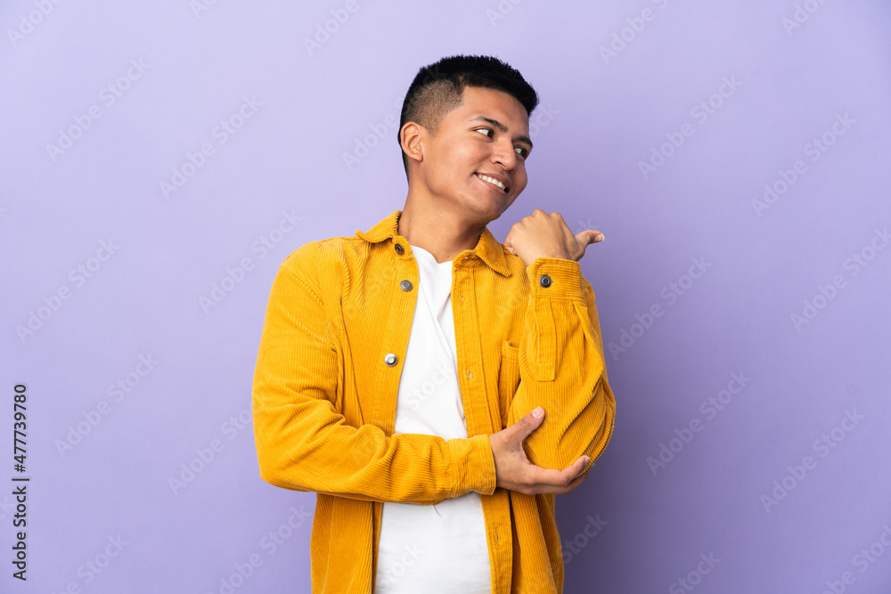 Young Ecuadorian man isolated on purple background pointing to the side to present a product Young Ecuadorian man isolated on purple background pointing to the side to present a product