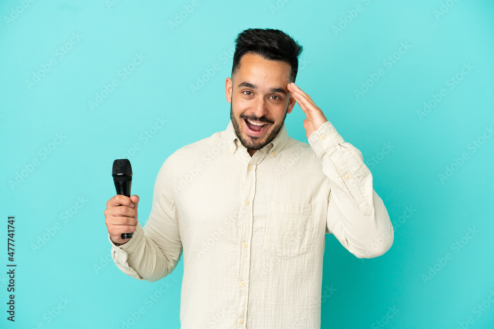 Young caucasian singer man isolated on blue background with surprise and shocked facial expression Young caucasian singer man isolated on blue background with surprise and shocked facial expression