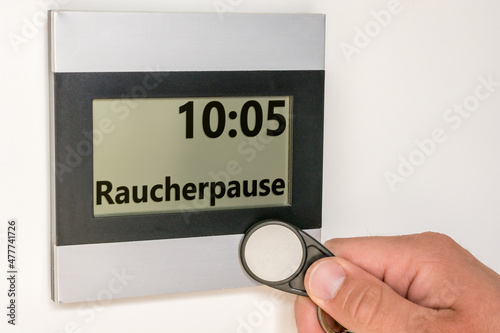 Stechuhr mit Uhrzeit und dem Wort für Raucherpause in deutscher Sprache photo