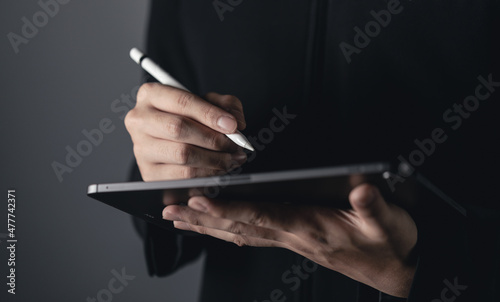 Businessman is working on tablet , man stock trading in smartpad. stock business or work from home concept. dark tone