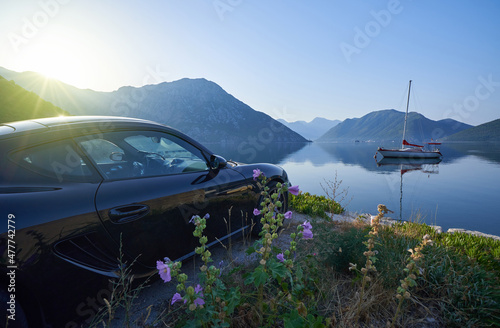 Sports car by the sea with mountain views, morning seascape with car