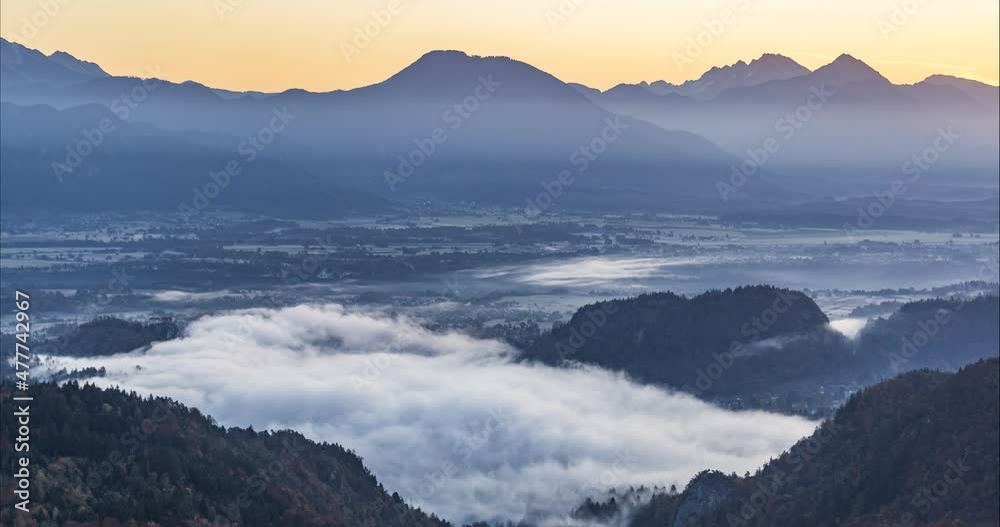 Time lapse of inversion clouds moving above lake Bled, Slovenia. Beautiful winter morning. Aerial or elevated view of large basin. Famous castle on rock and island on the lake. Static shot Time lapse of inversion clouds moving above lake Bled, Slovenia. Beautiful winter morning. Aerial or elevated view of large basin. Famous castle on rock and island on the lake. Static shot