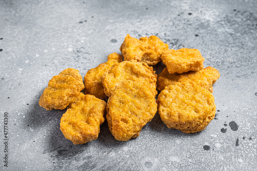 Fried crispy chicken nuggets on kitchen table. Gray background. Top view