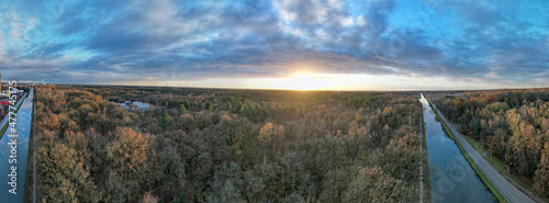 beautiful aerial panorama of a sunset over a river with green bushes and color rich sky, shot with a drone. High quality photo