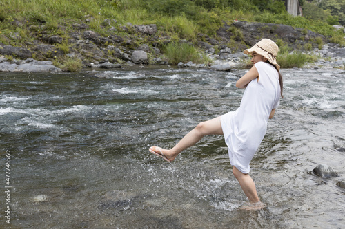 Fototapeta Naklejka Na Ścianę i Meble -  A girl playing with water in the river
