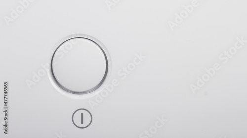 The start button, the on and off button of the device on the white surface