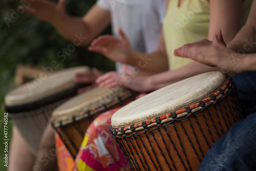 Group of people playing at djembe drums outdoor Fototapet
