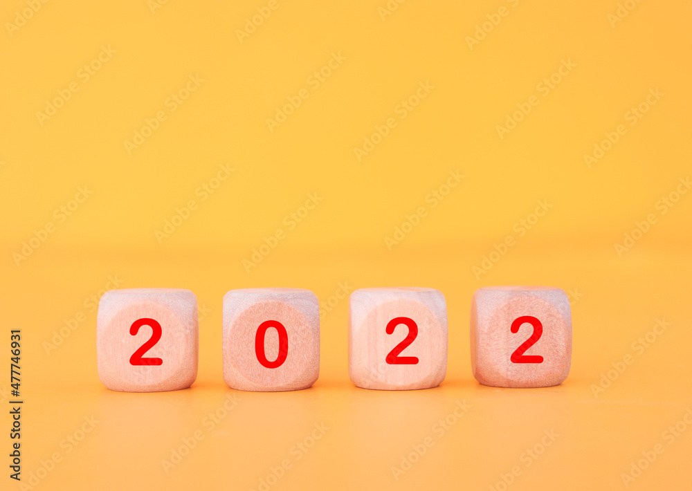 Wooden cube with 2022 text, concept to success of growing business. Wooden cube with 2022 text, concept to success of growing business.